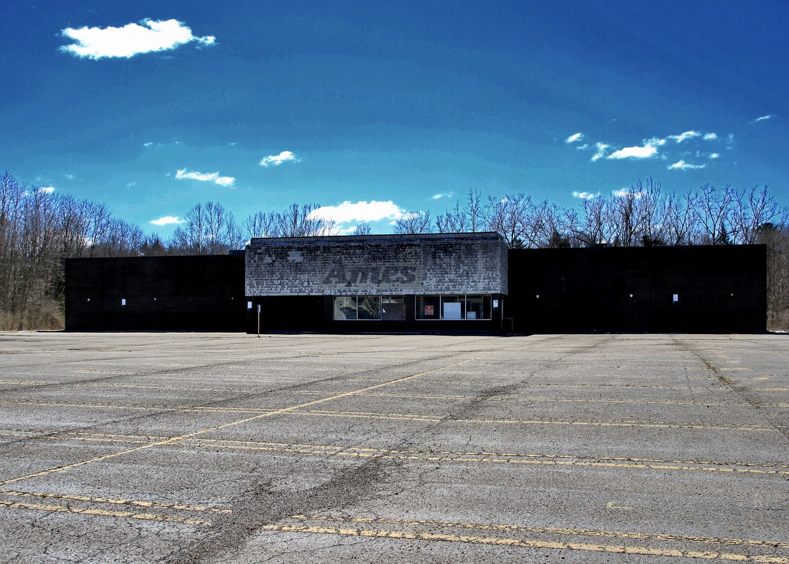 Abandoned Ames department store with empty parking lot in Collins