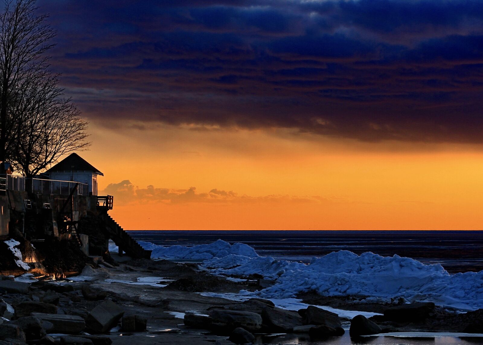Dramatic orange sunset over an icy Lake Erie shoreline near Hamburg